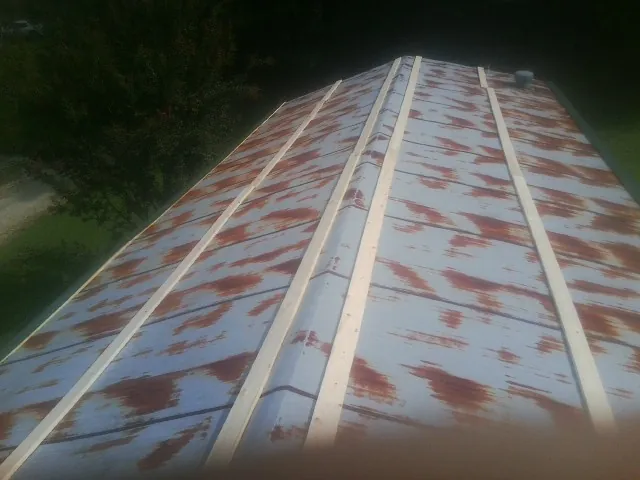 Rusted metal roof panels with new wood purlins before replacement — Storm Damage Roof Repair in Mattawana by Roofing Brothers