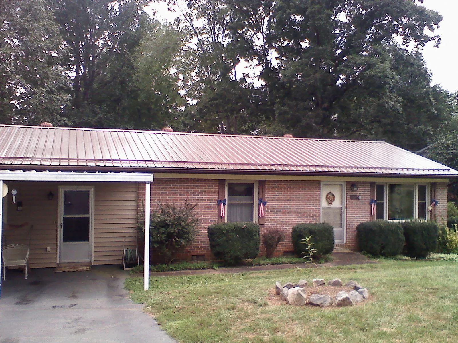 Bronze metal roof and carport on a brick ranch home — Roof Repair work by our crew in Mattawana