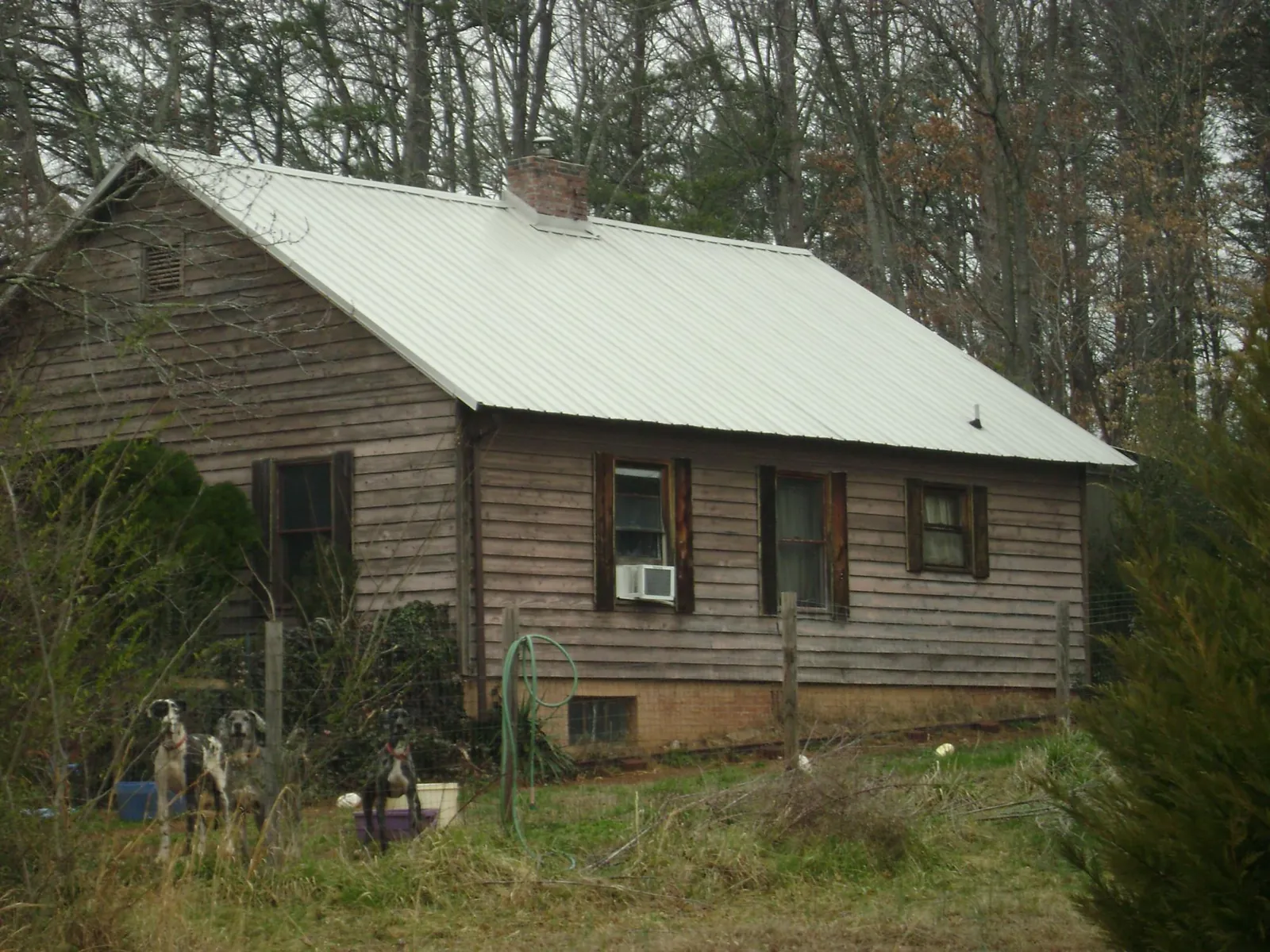 White metal roof on an old wood sided farmhouse, from a Metal Roof Installation job in Mattawana