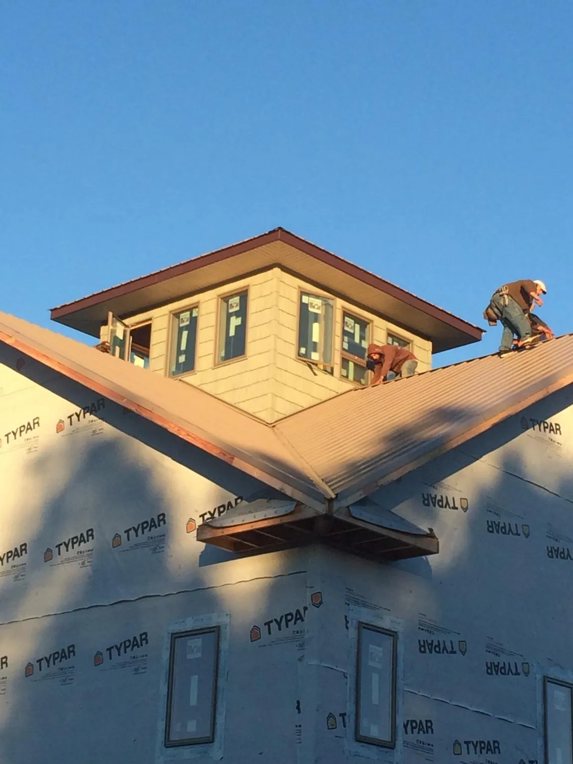 Roofers working around a rooftop cupola on a new metal roof at sunset — Roof Waterproofing in Mattawana by Roofing Brothers
